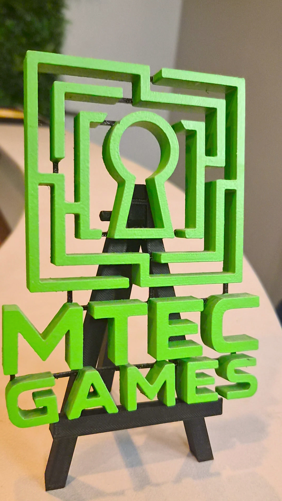 Groen MTEC Games-logo op een schildersezel