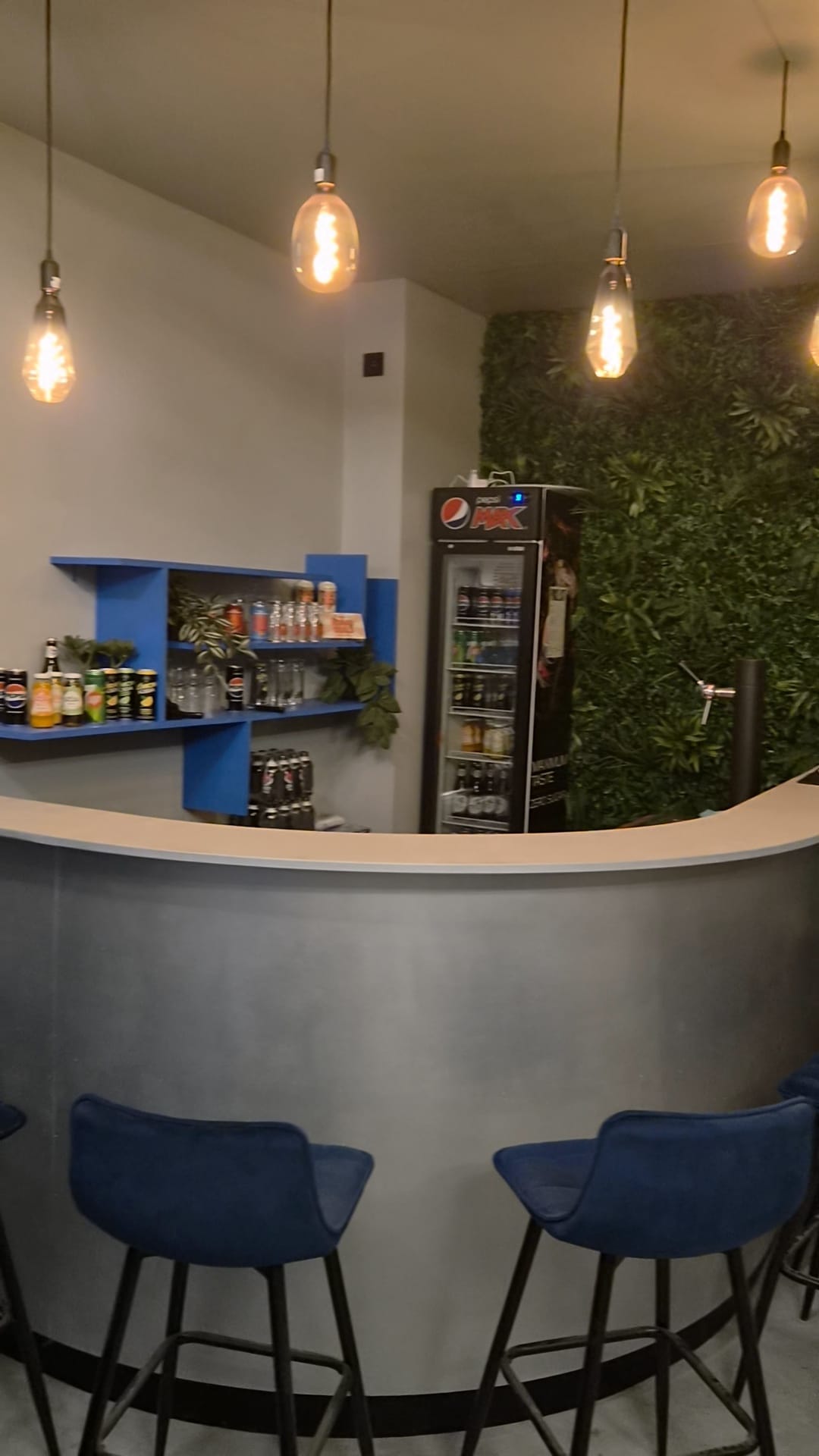 De bar van MTEC Games met hoge krukken en hangende lampen