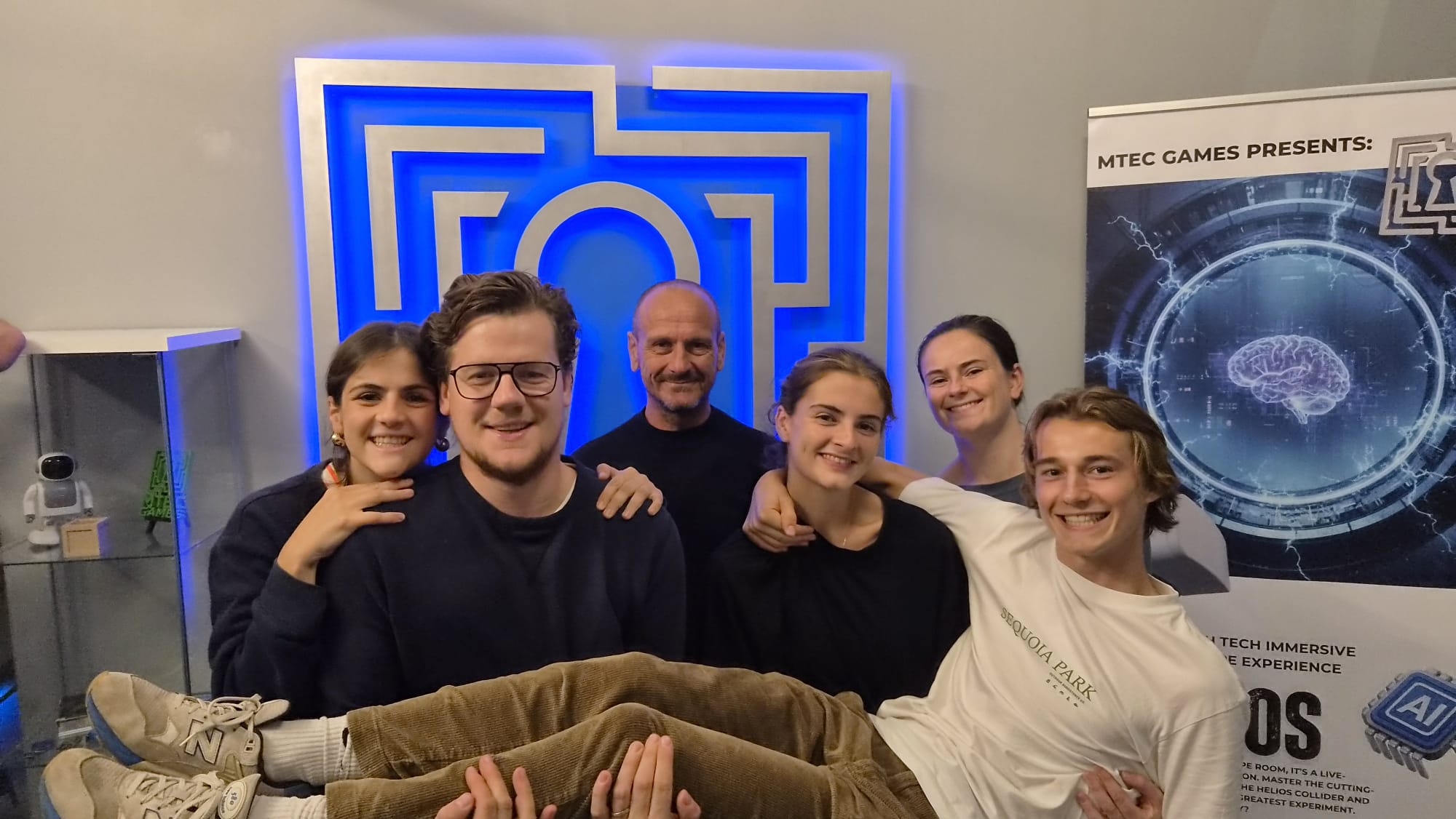 Een groep spelers voor de logomuur van MTEC Games
